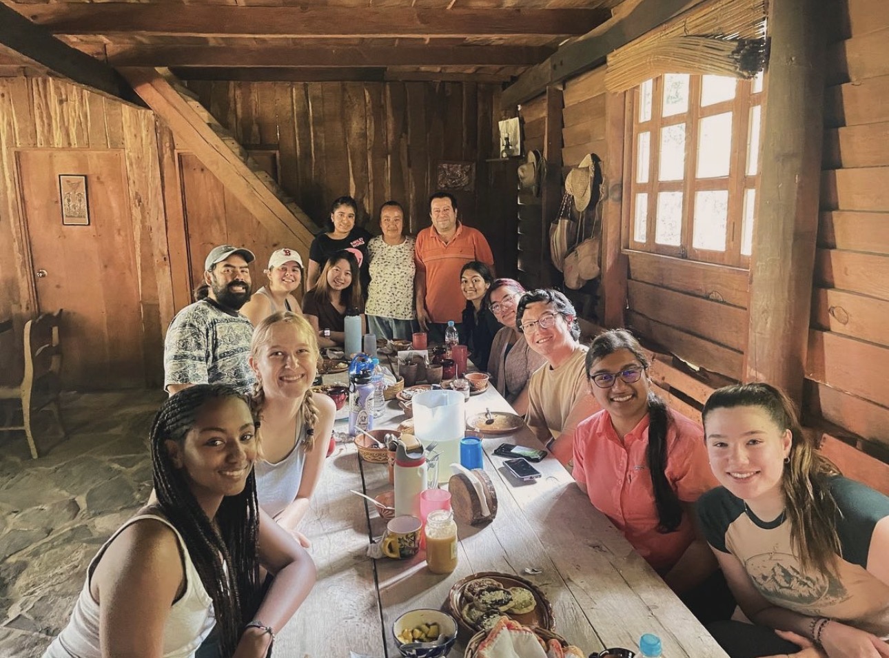 Students and community hosts gathered around a table in Mexico