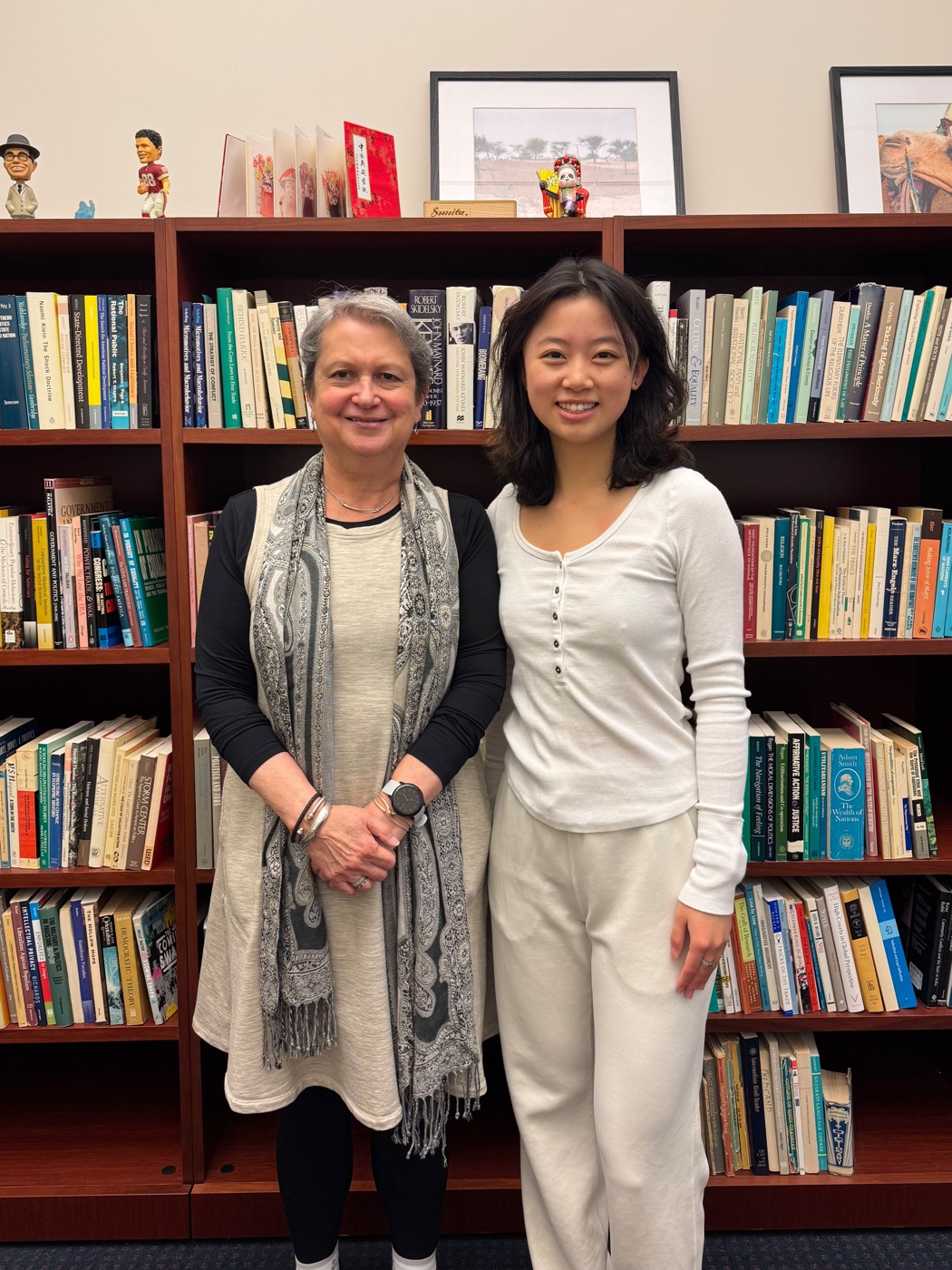 Buzhao Liu with Professor Sunita Parikh in front of political science bookshelves